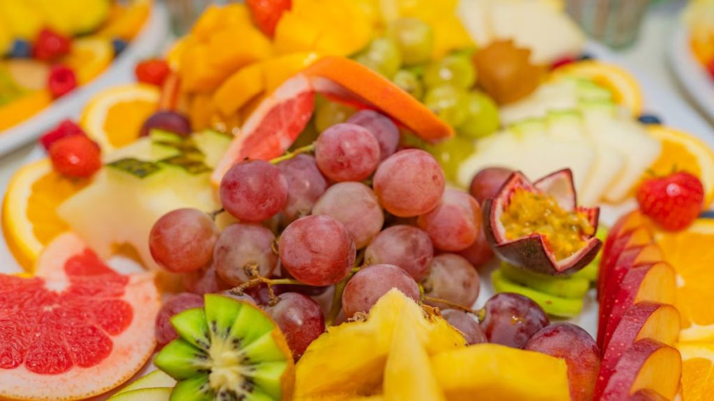 A variety of fresh fruits including grapes, kiwis, and passionfruit in a vibrant, healthy display.